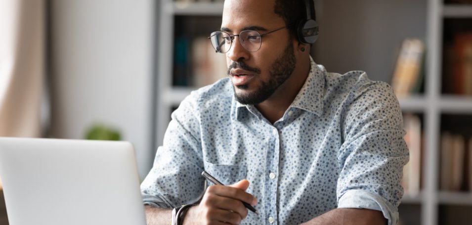 man focused at computer on a customer education strategy